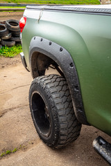 Fototapeta na wymiar Wheel of green offroad pickup truck close-up.