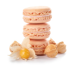 Tasty macarons with physalis on white background