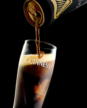 POLTAVA, UKRAINE - MARCH 22, 2018:  Guinness  beer is pouring into a glass. Guinness beer has been produced since 1759 in Dublin, Ireland.