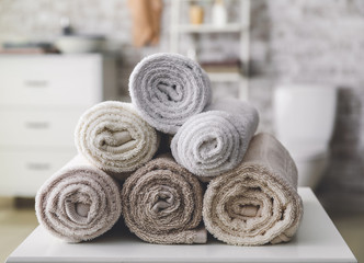 Fototapeta na wymiar Rolled towels on table in bathroom