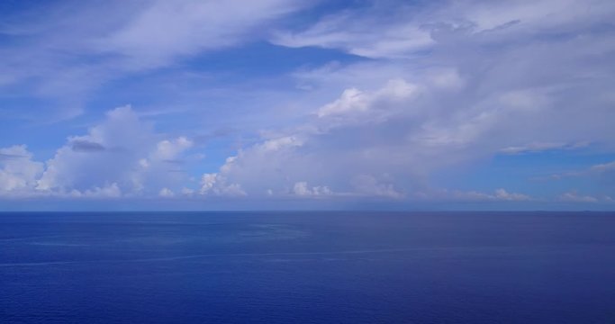 Peaceful scenery from bright heaven with big clouds hanging over deep blue ocean to the far horizon in Indian ocean, copy space