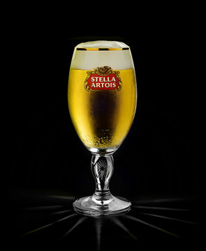 POLTAVA, UKRAINE - MARCH 22, 2018: Cold glass of Stella Artois beer on black background, prominent brand of Anheuser-Busch InBev, is a pilsner brewed in Leuven, Belgium, since 1926