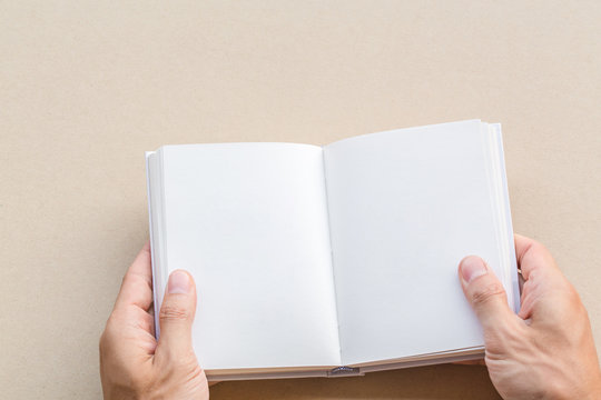 Man hand holding blank opened book mock up with white pages. empty paper page for add textbook or template art work design note book.