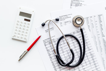 Health insurance concept. Stethoscope near financial documents and calculator on white background top view