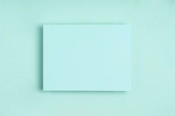 Minimal frame geometric composition mock up. Blank sheet of paper postcard on delicate blue background. Template design invitation card. Top view, flat lay, copy space. Horizontal