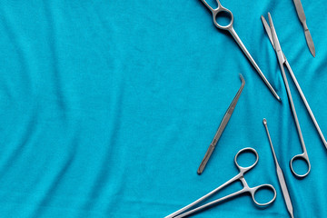 Plastic surgery. Instruments for beauty operations on blue background top view frame copy space
