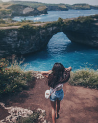 Girl on the broken beach on nusa penida island indonesia