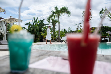 two cocktails and a man with a newspaper