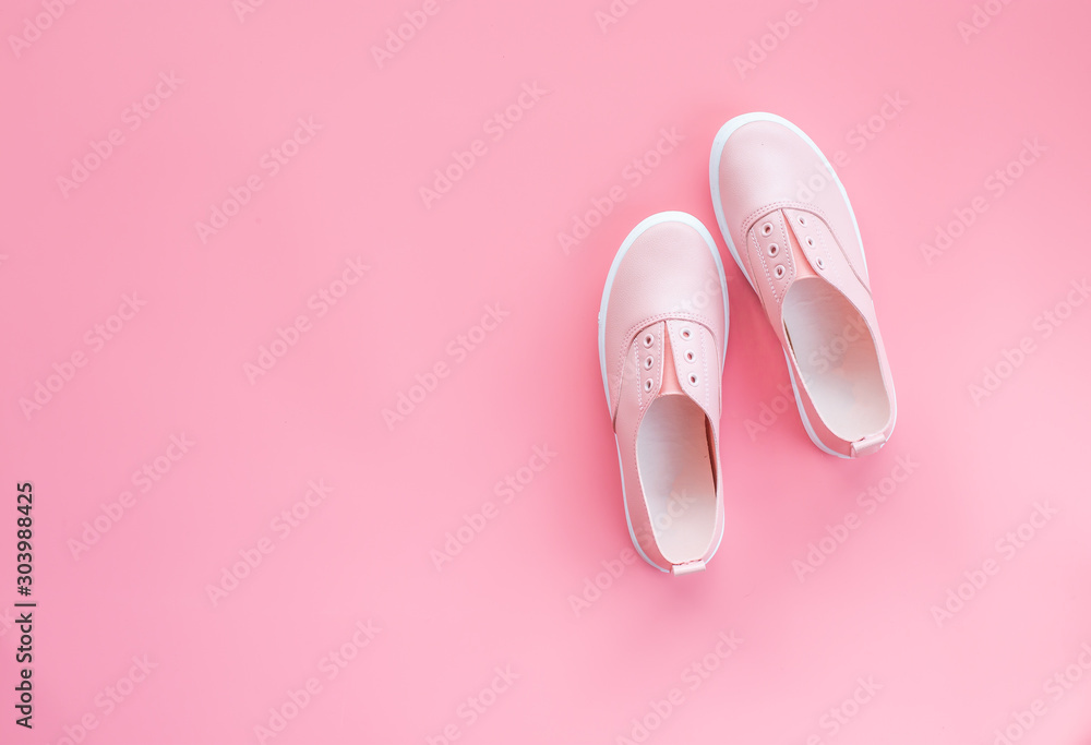 Wall mural one pair of pink casual shoe for woman on isolated pink background for poster, advertising or any is