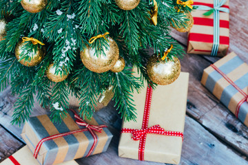 Christmas background. Green fir tree with golden balls and gift boxes.