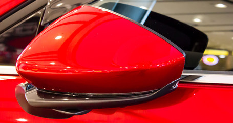 Obraz na płótnie Canvas red sports car/closeup of a car side mirror