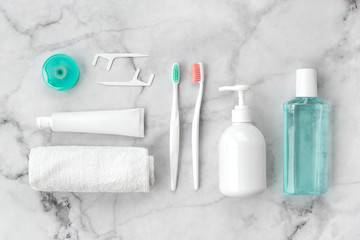 Set of pink and turquoise blue toothbrushes, toothpaste and other tools on marble background. Dental and health care concept. Top view, flat lay. - 303991899