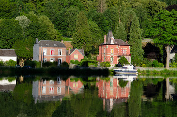 Obraz premium Colourful houses and tourist boats cruising along the River Meuse, Dinant, Namur, Belgium, Europe