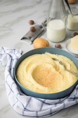 Schale Schüssel mit Kartoffelpüree mit Zutaten aus Kartoffeln, Milch, Salz, Butter, Muskatnuss dazu Küchentuch und Muskatreibe auf hell Marmor Hintergrund