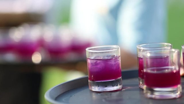 Purple drinking for serve on tray, waiter wait to serve water to guest in ceremony event. Have some for keeping after drink
