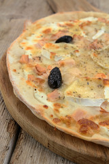 whole pizza with goat cheese on a wooden table