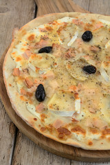 whole pizza with goat cheese on a wooden table
