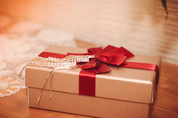 gift box with red ribbon and bow on wooden background