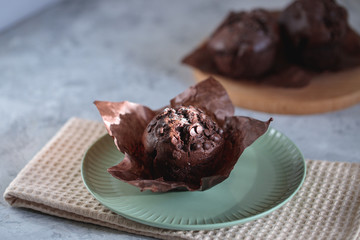 Chocolate muffin on a plate, close up. Fresh bakery.