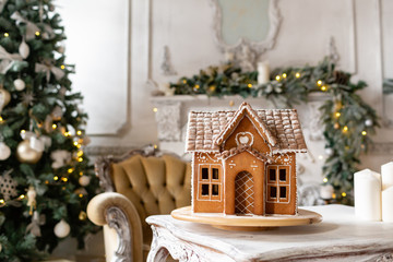 Postcard gingerbread house. Defocused lights of Christmas tree. Holiday mood. Christmas and Happy new year.