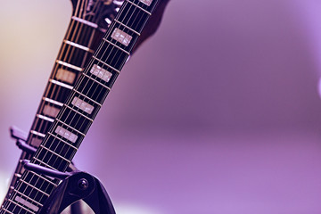 Electric and classical guitars with strings on a black background - concert preparation, stage light