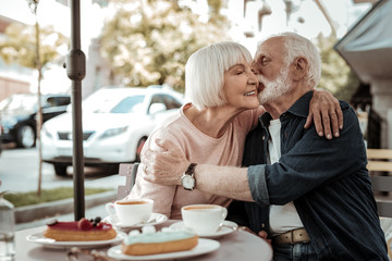 Nice grey haired man kissing his wife