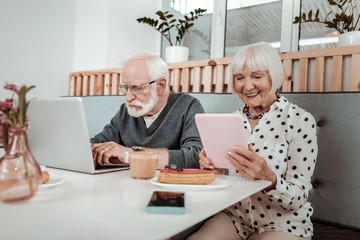 Pleasant elderly people using modern digital devices