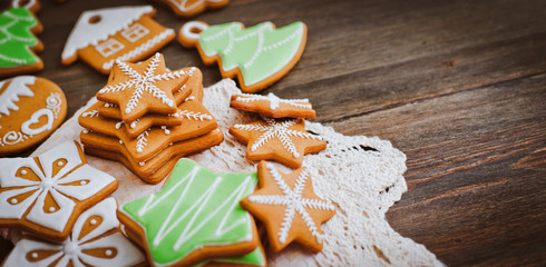 festive Christmas gingerbread cookies in the shape of a star lie on a wooden dark brown background.