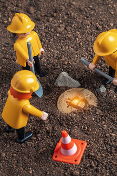 lego miner figures digging ground to uncover big glowing bitcoin