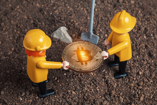 lego miner figures holding big glowing bitcoin in hands