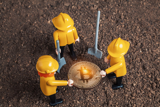 lego miner figures holding big glowing bitcoin  in hands