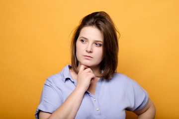 thoughtful emotional plus size model on a yellow background