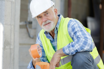 workman holding a tape indoors
