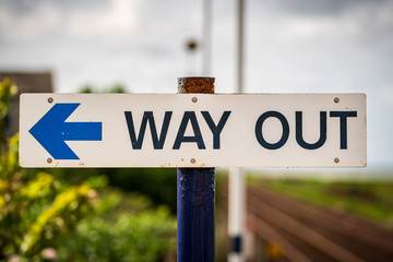 Sign: Way Out, with blurry background, seen in Kirkby-in-Furness, Cumbria, England, UK