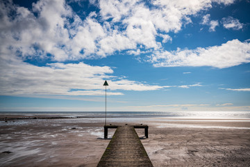 The beach and a wooden walkway in Seascale, Cumbria, England, UK