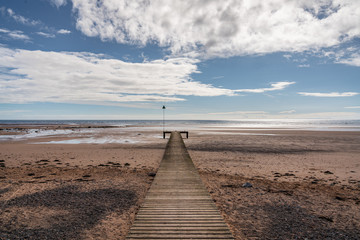 The beach and a wooden walkway in Seascale, Cumbria, England, UK