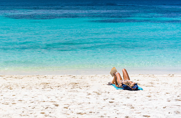 Fototapeta na wymiar Woman sunbathe on beach an Lipeh Satun Thailand while reading a novel book