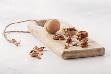 Walnuts on a wooden board on a light background