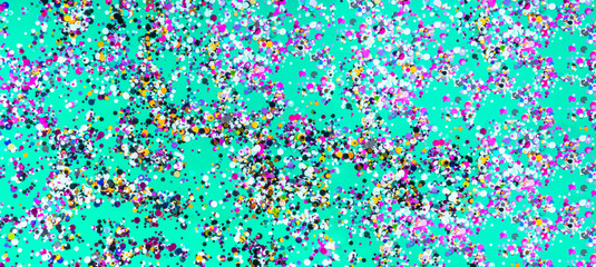 Festive neo mint surface with sparkling purple and blue confetti. Flat lay.