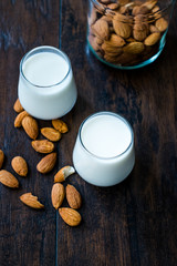 Almond Milk in Glass Cups with Almonds and Fabric Cloth.