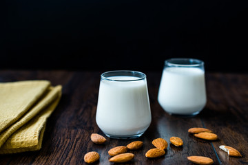Almond Milk in Glass Cups with Almonds and Fabric Cloth.