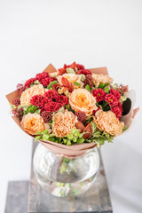 Beautiful bouquet of mixed flowers in glass vase. The work of the florist at a flower shop. Delivery fresh cut flower. European floral shop.