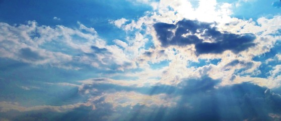 Sun breaking through clowds blue