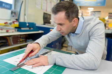 cutter in the studio with scissors cuts the pattern