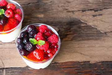Fruit yogurt has strawberry raspberry blueberry canberry and honey greek white clean In bowl on a wooden background from top view.