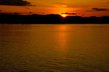 Sunset at sea with mountains in the background