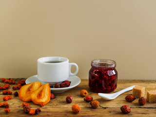 Herbal tea, jam and dried fruit on a yellow background. Space for text