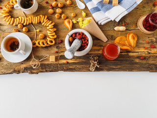 Herbal tea with ingredients and sweets on an old Board. White background with space for text