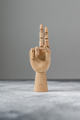 The wooden hand shows two raised fingers. The concept of communication.