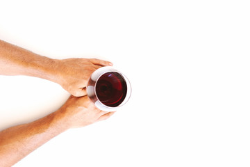 Male hand holding red wine in glass  over white isolated background. Flat-lay Wine degustation concept
